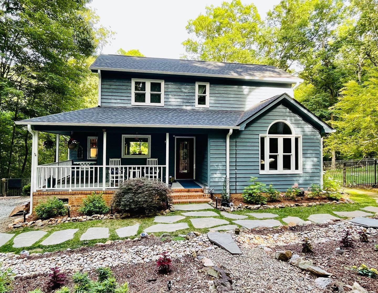 Blue craftsman home with painted porch columns and front door