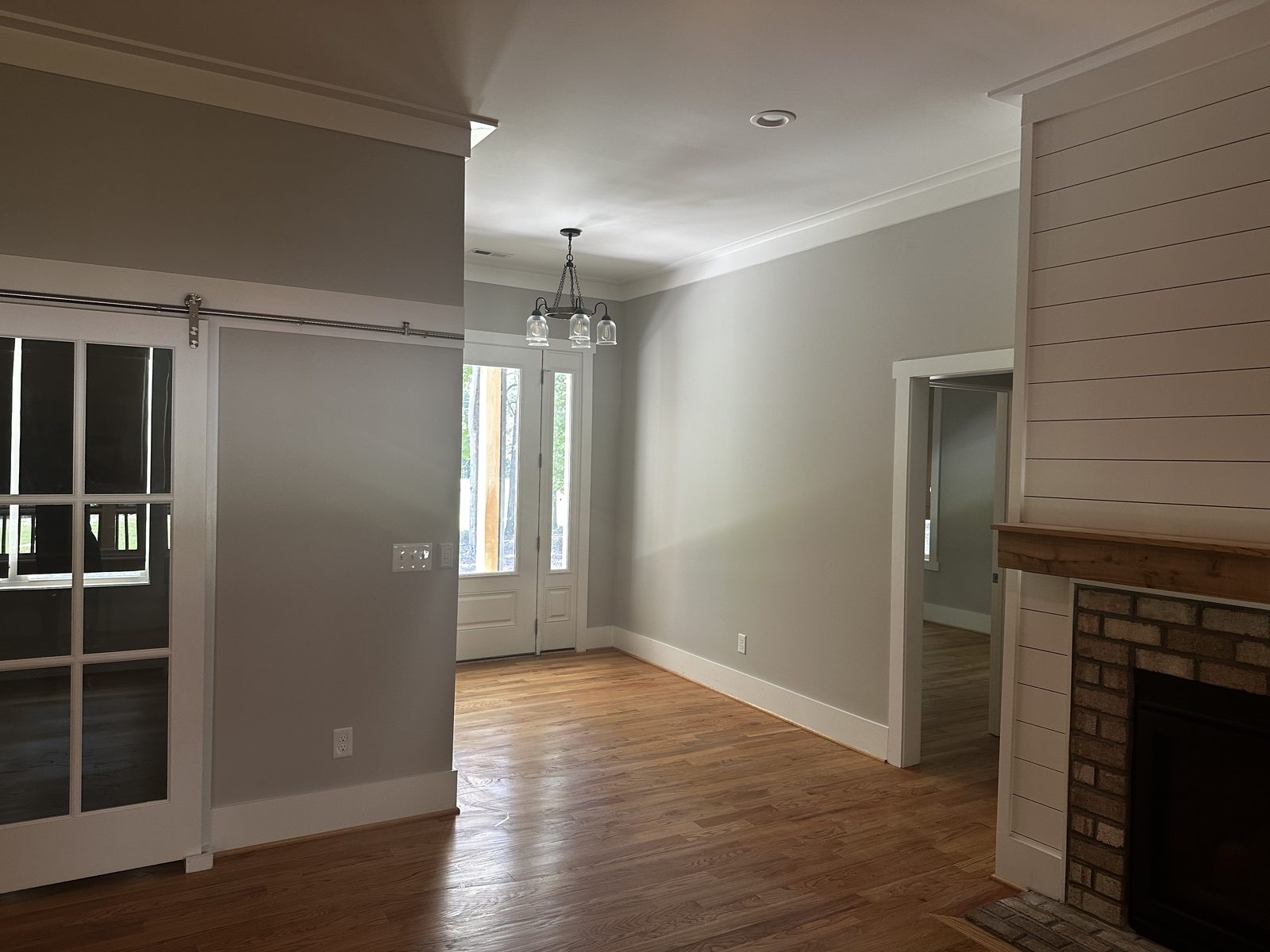 Open dining and living area with painted shiplap fireplace wall and white trim