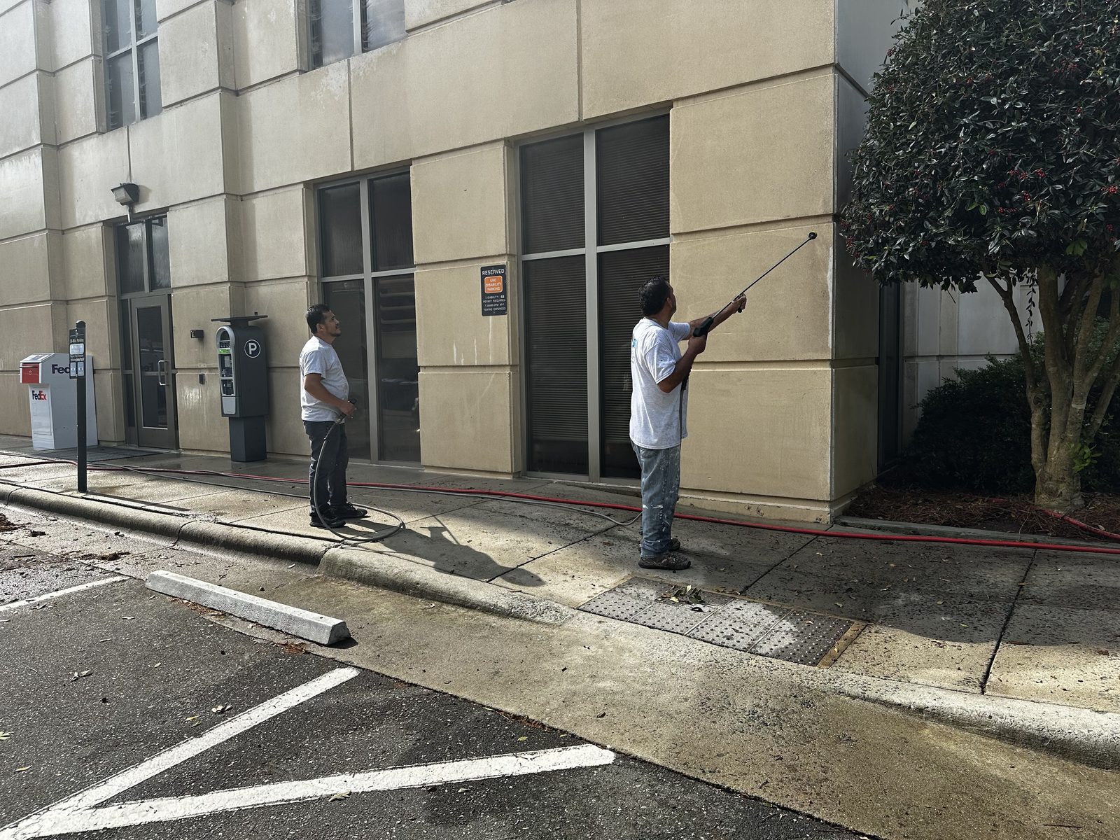 Building exterior being pressure washed before painting