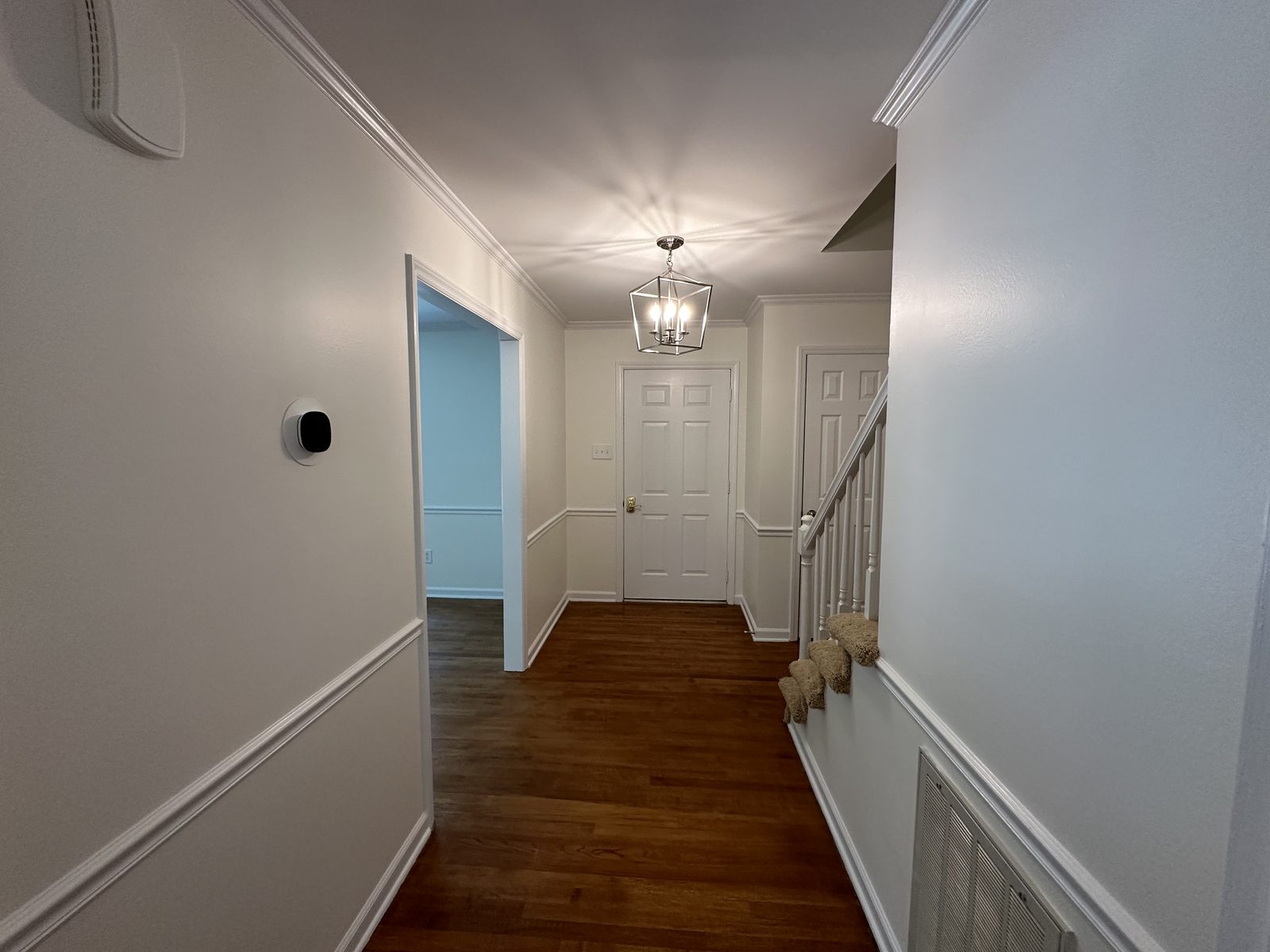 Hallway with fresh wall color above white wainscoting and painted doors