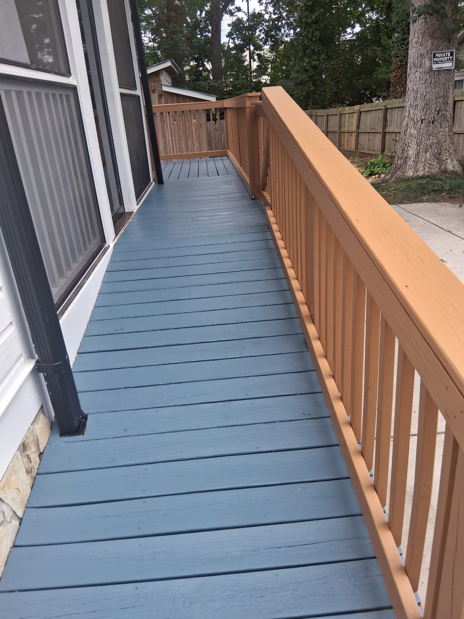 Long deck walkway with gray painted boards and tan railing