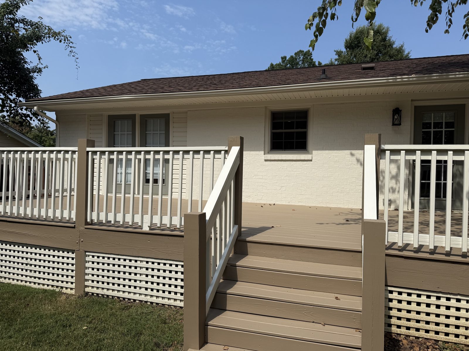 Tan deck with white railings and lattice skirting
