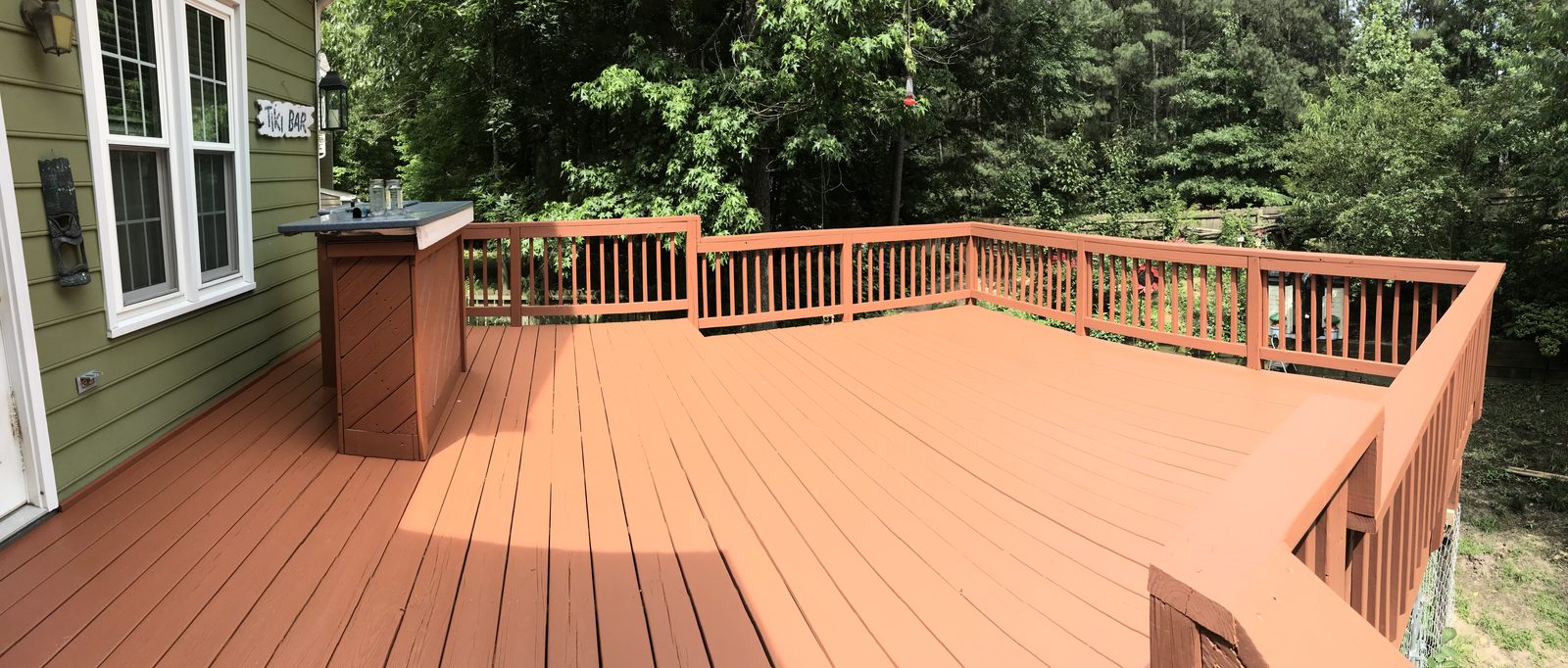 Large wraparound deck stained in a warm cedar color