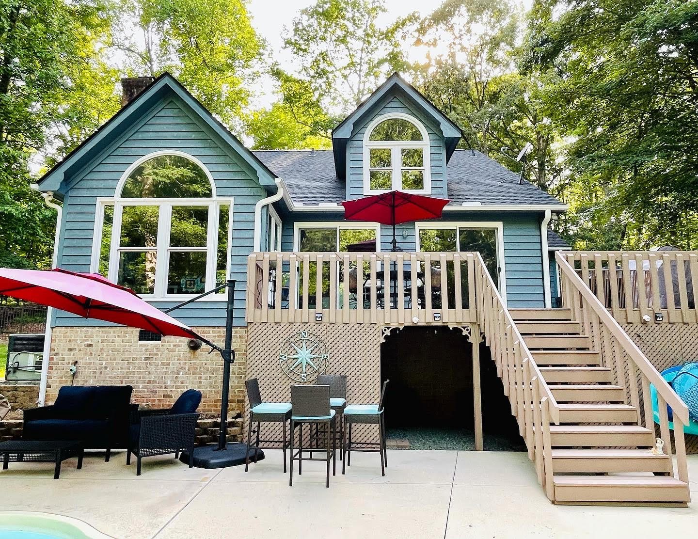 Two-story blue home with painted deck stairs and trim