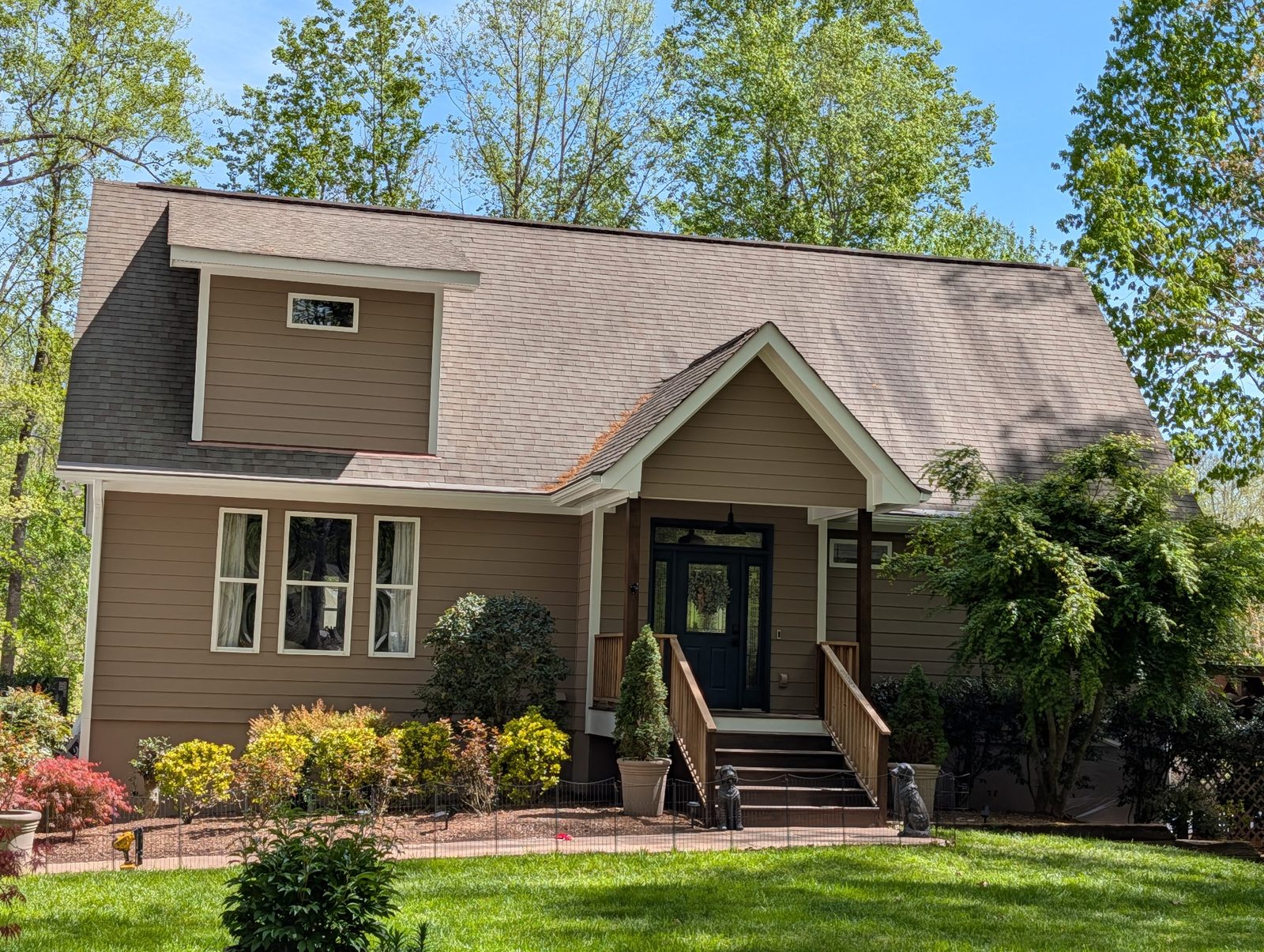 Tan craftsman home with painted trim and shutters