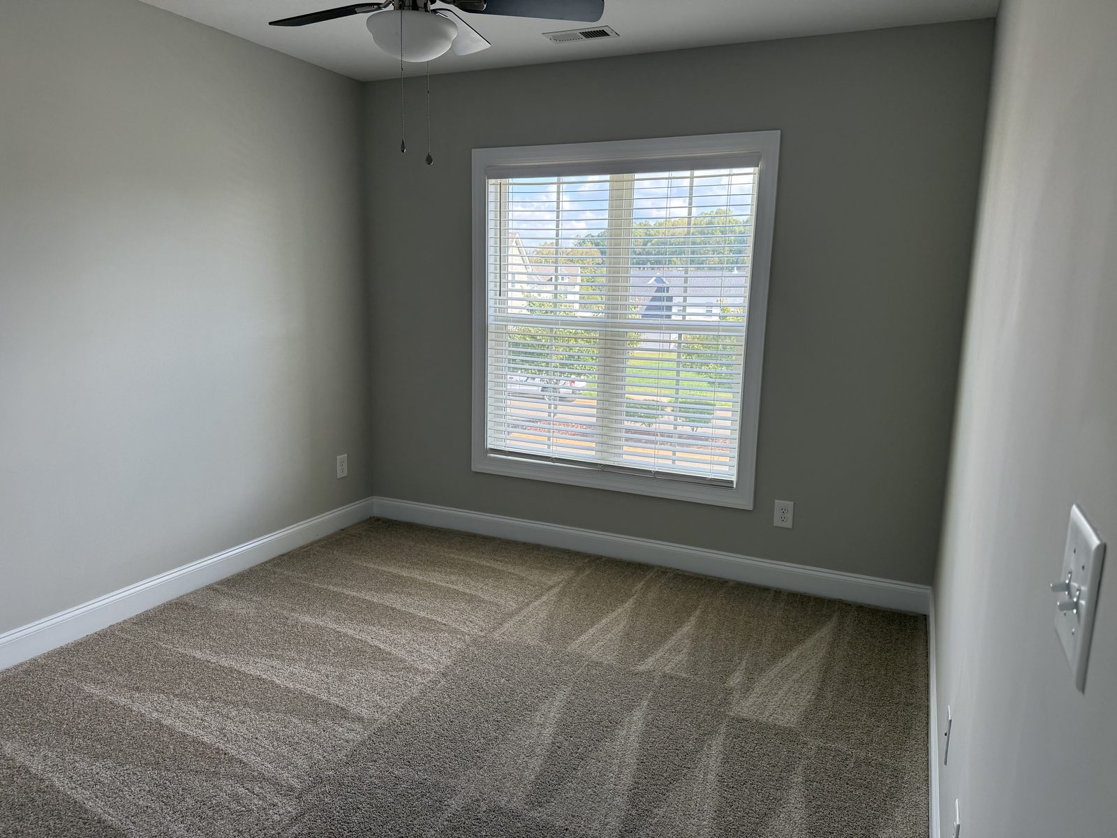 Bedroom painted a soft gray-blue with white baseboards — interior painting by Roca’s Painters of Mebane, NC