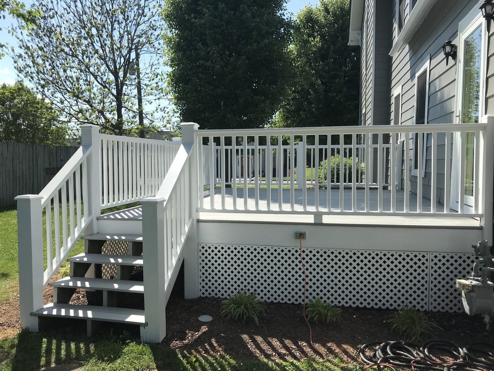 Deck with bright white railings, steps, and lattice skirting