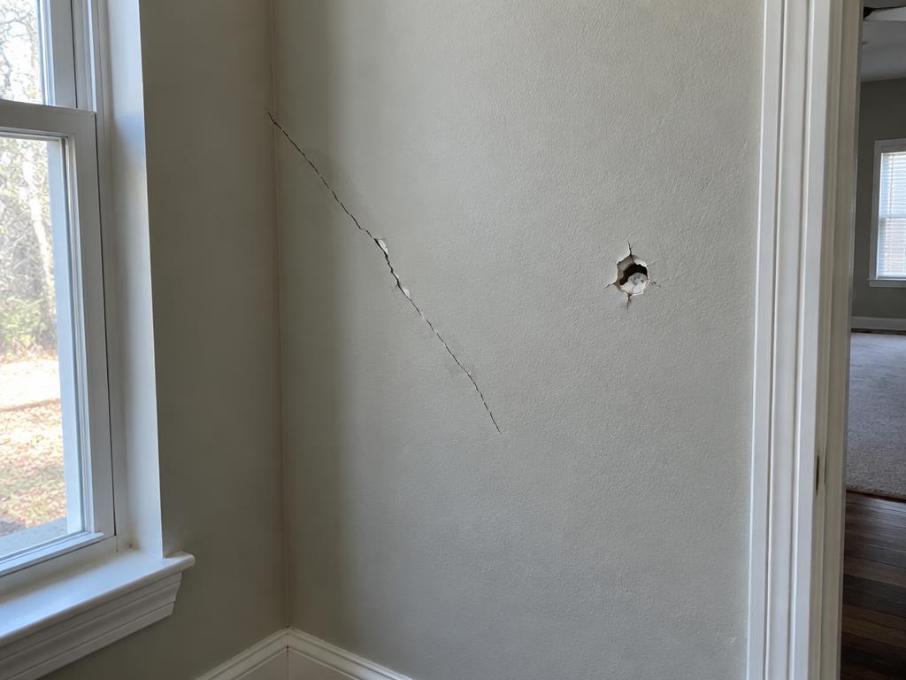 Cracked and punctured drywall before repair